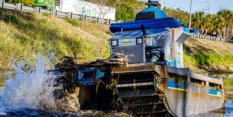 Rear View of a Truxor DM 5045 Model Splashing Through a Canal