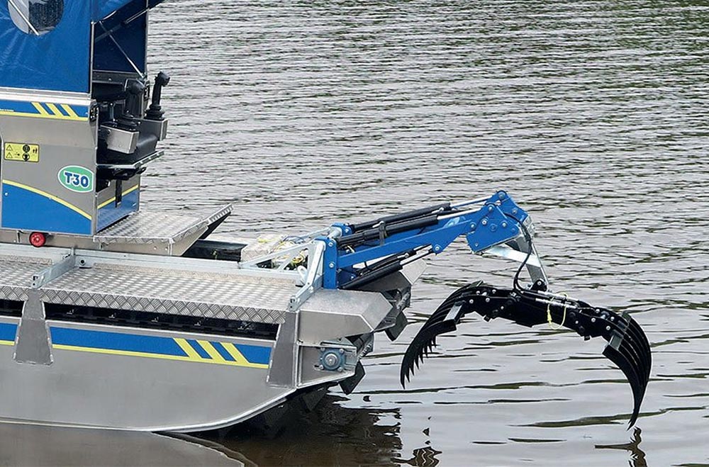 Truxor T30 with DoroGrip Rake attachment collecting lake debris
